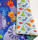 Custom name dino baby quilt in nursery setting