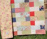 Modern, easy-to-make throw quilt – Stepping Stones PDF pattern from Kristin Blandford Designs, using colorful 10" layer cake squares.