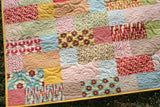 Stepping Stones throw quilt pattern by Kristin Blandford Designs – modern design made with 10" layer cake squares, perfect for DIY home décor.