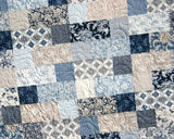 Throw size quilt pattern, Stepping Stones – created with colorful layer cakes for a fast and fun finish by Kristin Blandford Designs.
