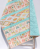 Modern baby quilt pattern featuring colorful diagonal strip piecing and beginner-friendly quilt construction in a bright contemporary design.