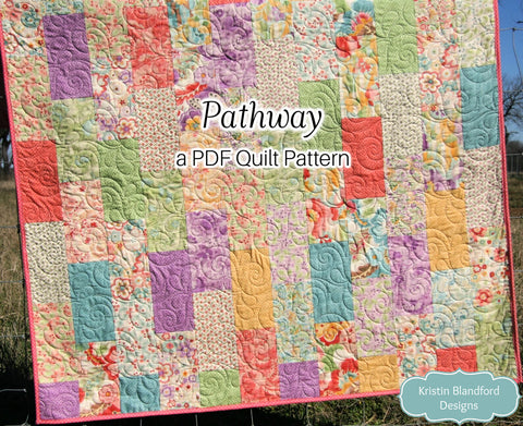 Modern layer cake quilt pattern featuring pastel floral patchwork fabrics arranged in a balanced scrappy layout with beginner-friendly quilt construction.
