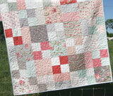 Throw size Whimsy Quilt by Kristin Blandford Designs featuring bold florals and a modern layout – a fast and fun quilting project. Porcelain by Moda Fabrics