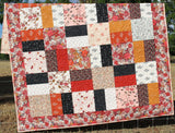 Modern floral quilt pattern with coordinated shabby chic fabrics arranged in a timeless patchwork design for baby and throw quilts.