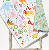 Colorful alphabet baby quilt featuring animals A through Z, custom name embroidery, handmade cotton blanket for nurseries.