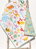Custom colorful ABC baby quilt with embroidered name, handmade cotton blanket featuring alphabet learning and animals.