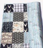Woodland quilt kit featuring navy and gray tones with deer, owls, feathers, and teepee prints for handmade blankets.