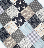 Navy woodland quilt kit including rustic patchwork fabrics with deer, owls, feathers, and teepees for handmade baby quilt.