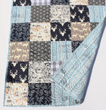 Rustic woodland patchwork kit with navy and gray cotton fabrics, deer and owl prints, and teepee patterns.