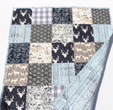 Rustic woodland patchwork quilt kit with navy and gray fabrics, beginner-friendly design, and forest-inspired animal prints.