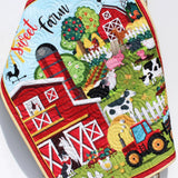 Personalized farmyard baby quilt with red barn, tractors, cows, pigs, and embroidered monogram on soft cotton fabric.