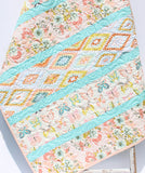 Nursery quilt kit with striped fabric layout and soft pastel colors