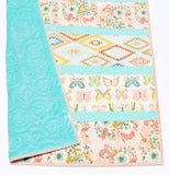 Floral butterfly baby quilt designed as cozy nursery bedding and crib blanket