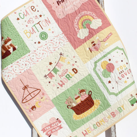 Personalized baby quilt with pink and green nursery panel and embroidered name