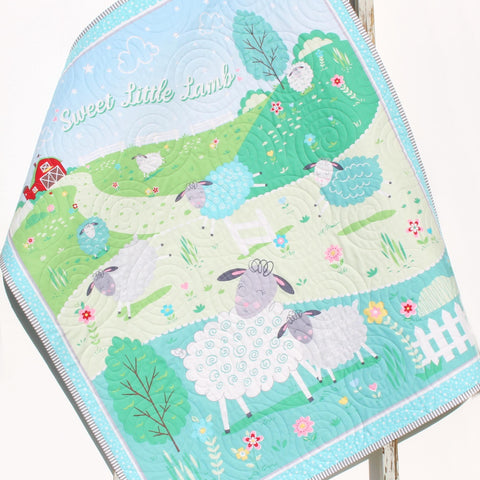 Handmade baby quilt featuring the Sweet Little Lamb nursery design with sheep and pastel colors