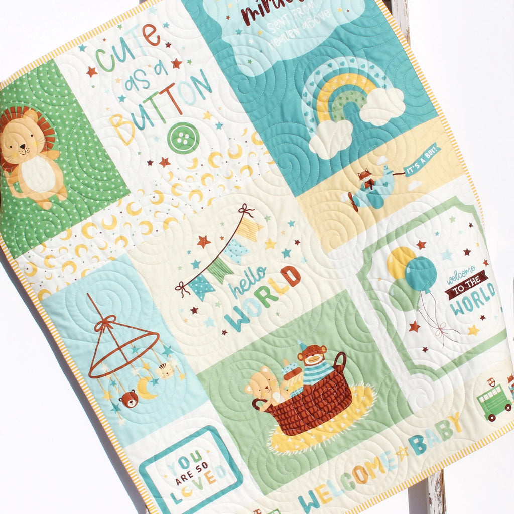 Handmade baby boy quilt featuring a playful nursery panel with animals and soft blue and green tones