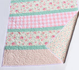 handmade cotton quilt with floral prints, gingham center stripe, and mint accents