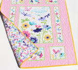 Baby quilt made from a butterfly quilt panel with pink and floral fabric accents