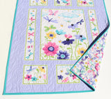 Custom embroidered baby quilt featuring butterfly and floral artwork