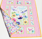 Handmade girls nursery blanket featuring butterflies and floral quilt panels