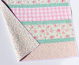 handmade floral quilt featuring soft pink gingham and mint green striped design